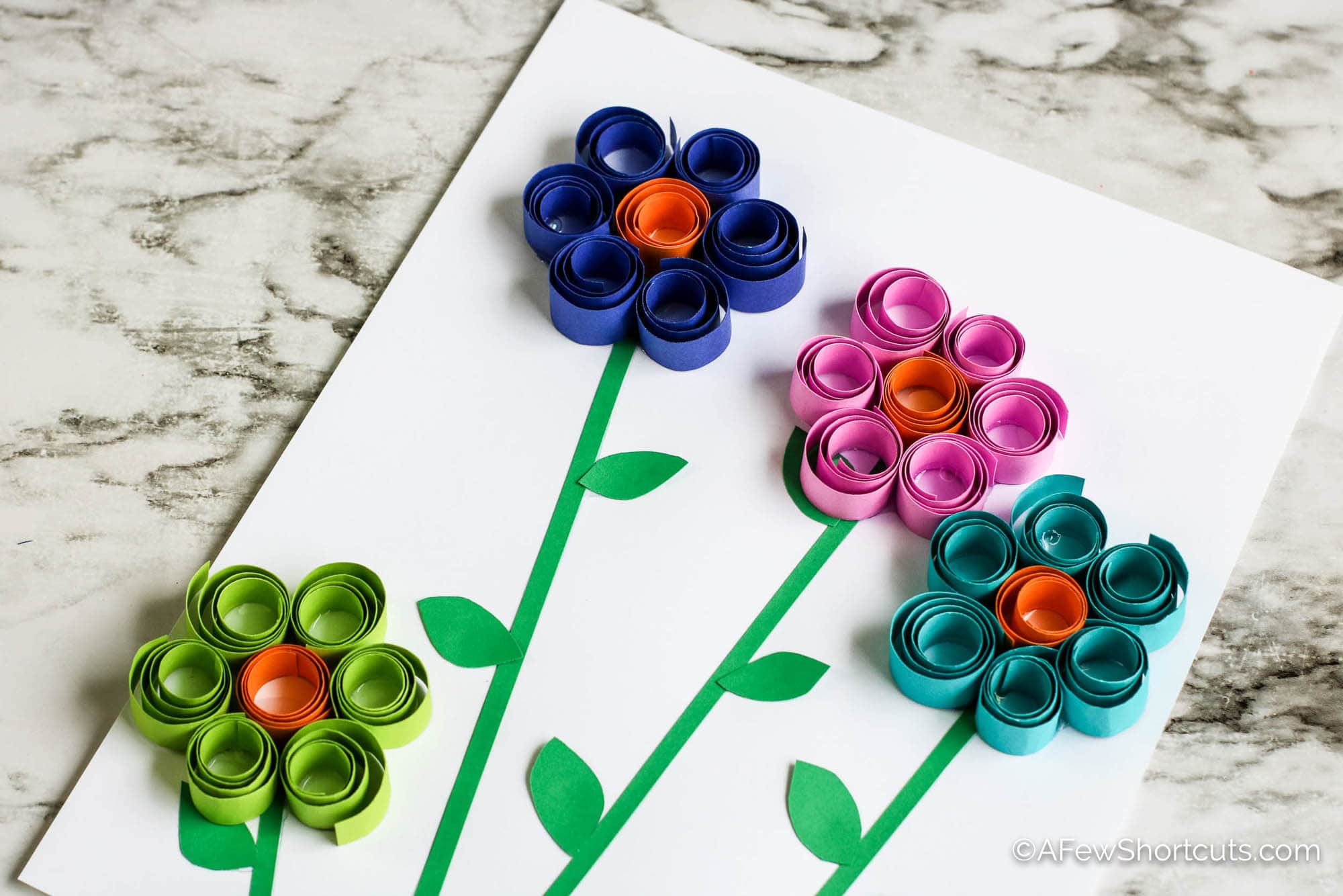 Four quilled paper flowers with stems
