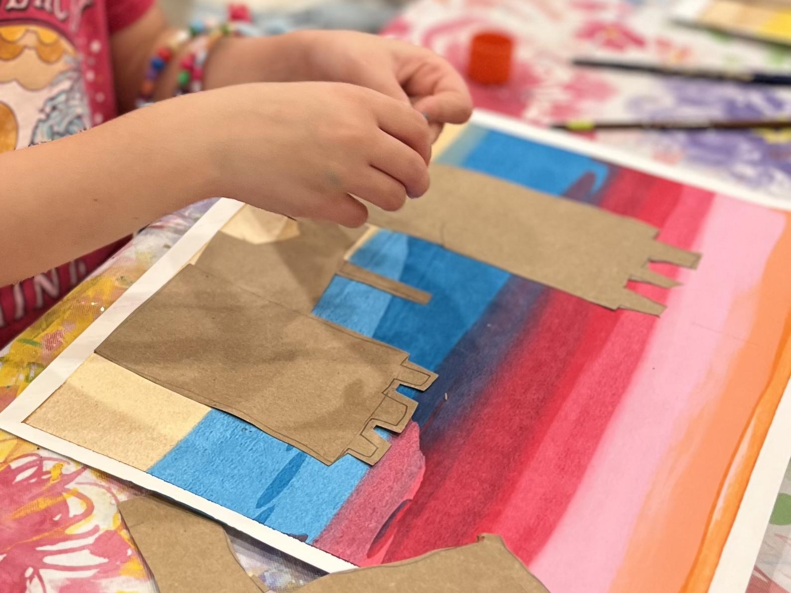 child working on squeegee sandcastle painting